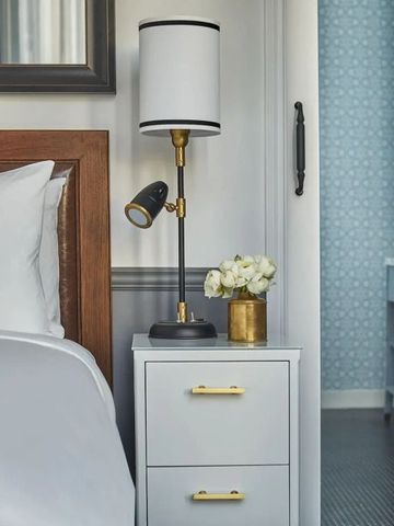 Elegantes Hotelzimmer mit Nachttisch, Lampe und moderner Dekoration.