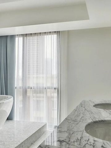 Modernes Badezimmer mit freistehender Badewanne und Marmorwaschtisch.