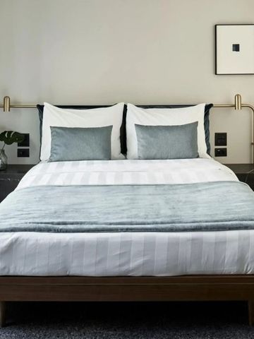 Elegantes Schlafzimmer mit minimalistischer Einrichtung und modernen Annehmlichkeiten