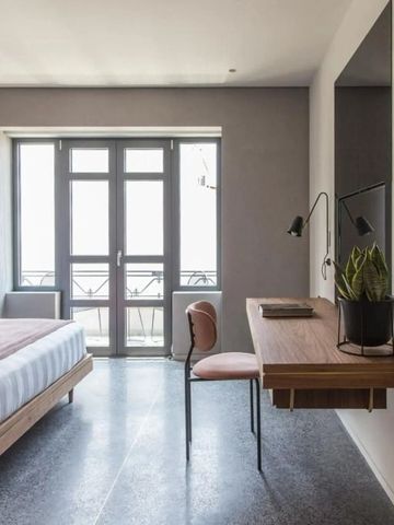 Modernes Hotelzimmer mit Schreibtisch und großem Fenster