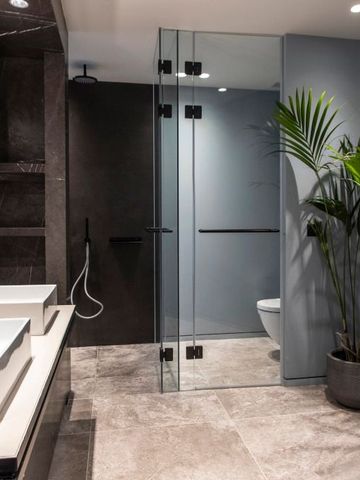 Stylisches Badezimmer mit Glasdusche und Pflanzen