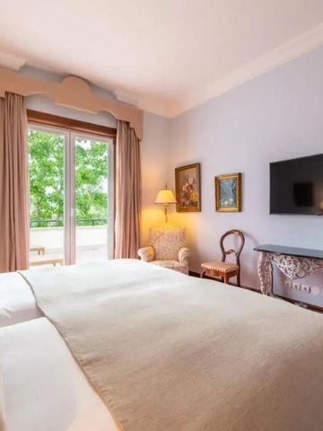 Elegantes Hotelzimmer mit großen Fenstern und Himmelbett im Pestana Palace Lisboa