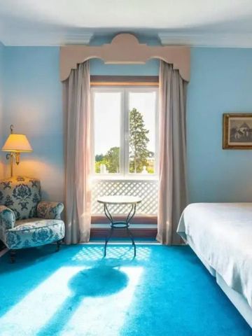 Helles Hotelzimmer mit großem Fenster und Sitzbereich im Pestana Palace Lisboa