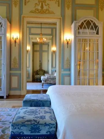 Elegantes Hotelzimmer mit großem Bett und stilvoller Einrichtung in Pestana Palace Lisboa
