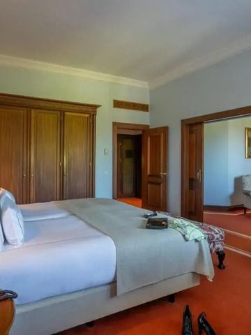 Komfortables Hotelzimmer mit Doppelbett und Holzmöbeln im Pestana Palace Lisboa