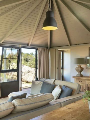 Modernes Wohnzimmer mit Holzdecke und großer Fensterfront