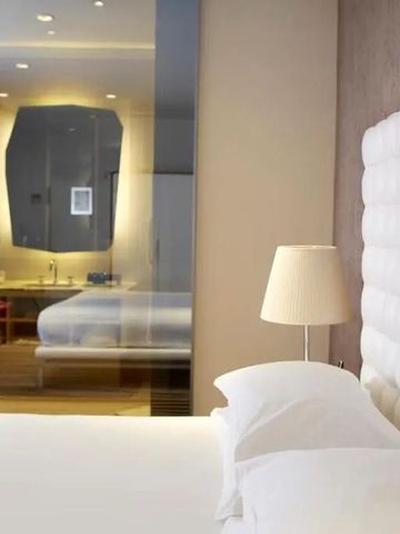 Geräumiges Zimmer mit elegantem Bett und offenem Baddesign