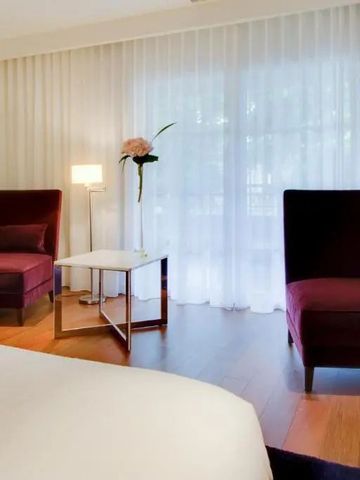 Lichtdurchflutetes Zimmer mit eleganter Sitzecke und großen Fenstern