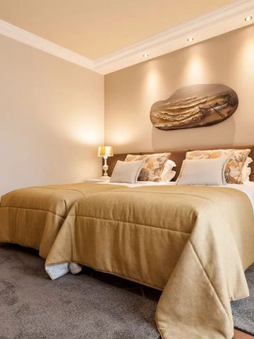 Hotelzimmer mit zwei Einzelbetten, luxuriöser Ausstattung und warmer Beleuchtung.