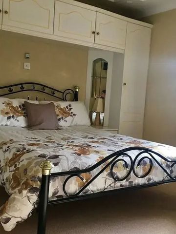 Hübsch eingerichtetes Schlafzimmer mit Blumenmuster und Spiegelschrank