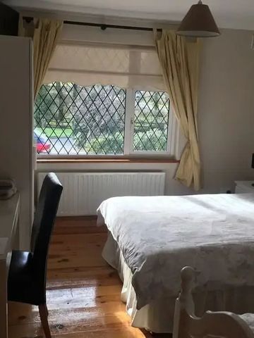 Helles Schlafzimmer mit Schreibtisch und Holzfußboden