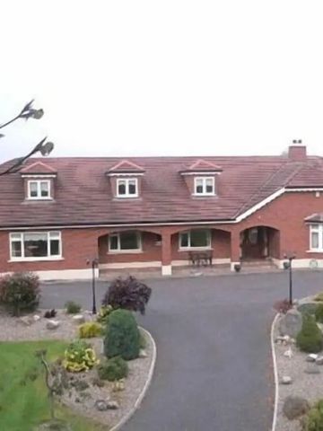 Luftaufnahme eines rot verklinkerten Hauses mit Garten