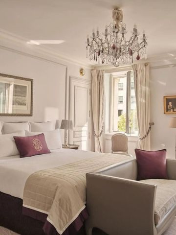 Schlafzimmer mit luxuriösem Bett, Kronleuchter und klassischen Möbeln