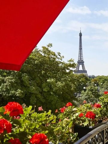 Aussicht von einem Balkon mit rotem Sonnenschirm und Blick auf den Eiffelturm