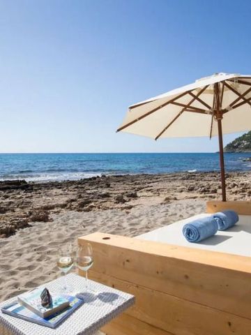 Strandbereich mit Liege, Sonnenschirm und Meerblick