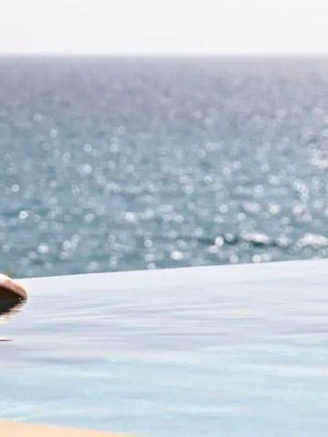 Infinity-Pool unter strahlender Sonne mit Blick auf das endlose Meer