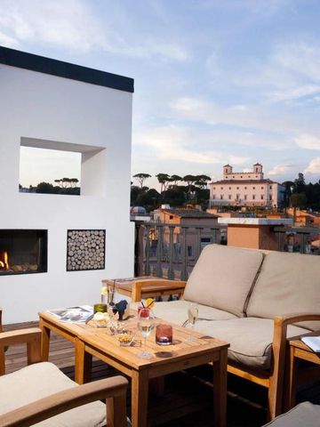 Dachterrasse mit gemütlicher Sitzgruppe und Blick über die Stadt bei Sonnenuntergang