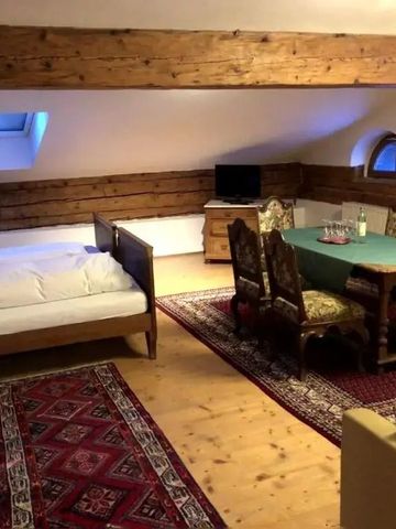 Großzügiger Dachbodenraum mit Holzbalken und stilvollem Essbereich