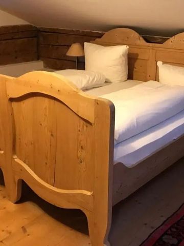 Rustikales Holzbett in einem traditionell eingerichteten Zimmer