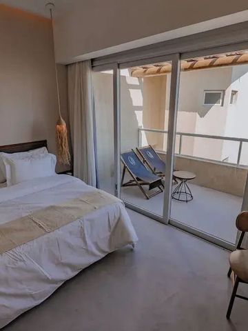 Hotelzimmer mit Balkon und Liegestühlen sowie Blick auf den Innenhof