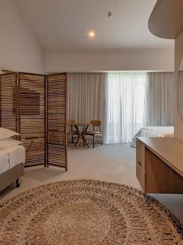 Elegantes Hotelzimmer mit runden Teppich und hellem Interieur