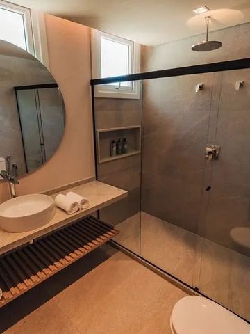 Luxuriöses Badezimmer mit Regendusche und rundem Spiegel