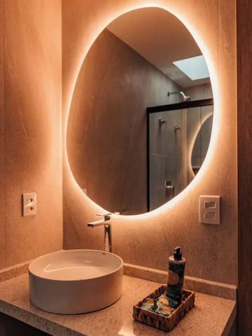 Beleuchteter runder Spiegel im eleganten Badezimmer