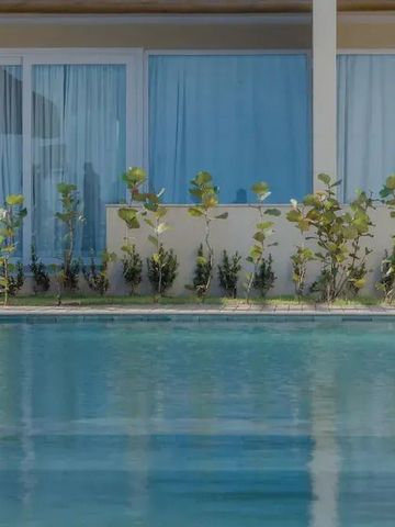 Außenansicht eines Pools vor einem Gebäude mit modernen Glastüren