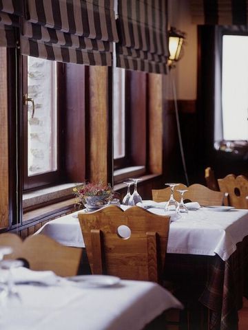 Gemütliches Restaurant mit schlichter Tischdekoration und großen Fenstern