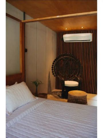 Stilvolles Schlafzimmer mit Holzelementen und einem Designerstuhl.