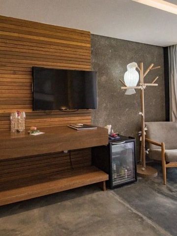 Moderne Zimmereinrichtung mit Holzverkleidung, Sessel und TV.