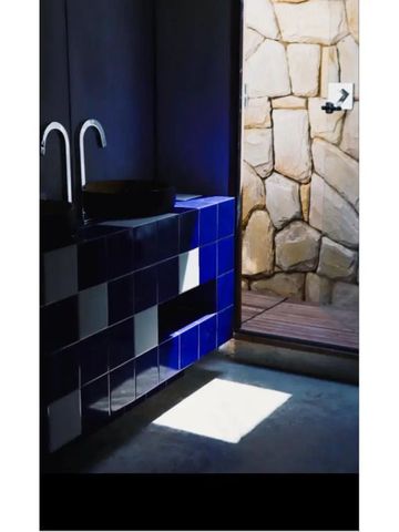 Stilvolles Badezimmer mit blauen Fliesen und natürlichem Licht.