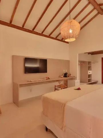 Elegantes Zimmer mit Flachbildfernseher und Holzakzenten im Hotel Pousada Tatuá