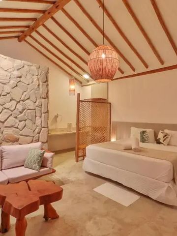 Zimmer aus Stein und Holz mit Sitzbereich im Hotel Pousada Tatuá