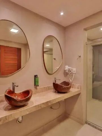 Modernes Badezimmer mit zwei ovalen Spiegeln und eleganten Waschbecken