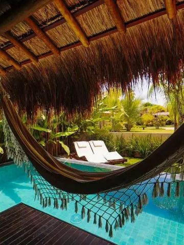 Hängematte über einem Pool mit tropischer Kulisse