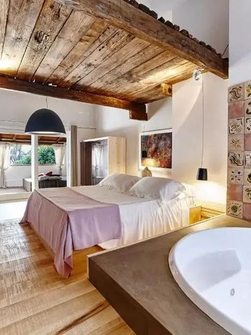 Luxuriöse Suite mit Holzbalkendecke und Whirlpool