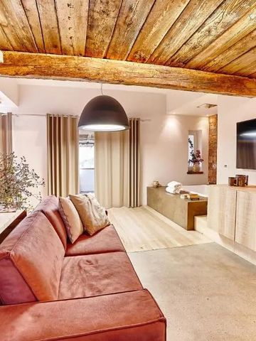 Helles Zimmer mit Holzbalkendecke und stilvoller Einrichtung