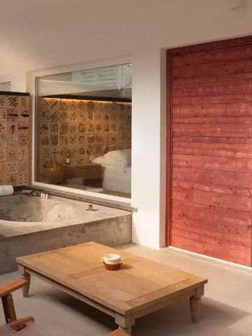 Luxuriöses Bad mit Holzdetails und Einblick in ein Schlafzimmer