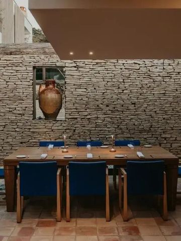 Stilvoller Essbereich mit Steinwand und rustikalem Holztisch