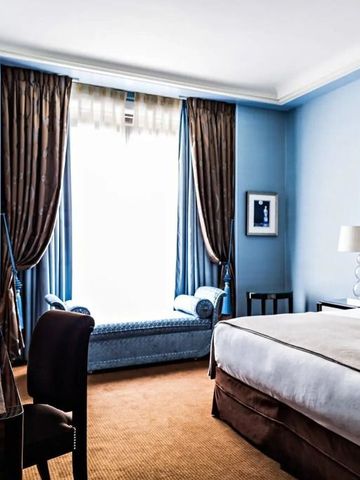 Hotelzimmer in Blau und Braun mit großzügigem Fenster und edler Einrichtung