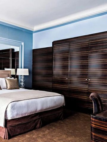 Elegantes Hotelzimmer mit Kingsize-Bett und Holzvertäfelung