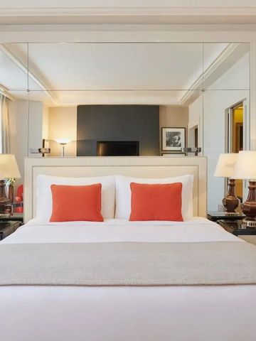 Helles Doppelzimmer mit Spiegelwand und orangen Akzenten