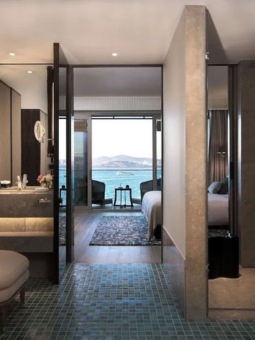 Luxuriöse Suite mit Blick auf das Meer durch große Fenster von Badezimmer und Schlafzimmer