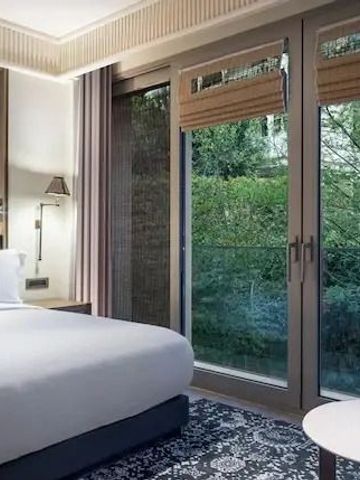 Helles Hotelzimmer mit Blick auf den Garten durch große Fenster