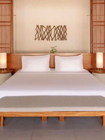 Zimmer mit zentralem Doppelbett und kunstvollen Holzelementen