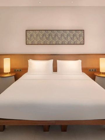 Modern eingerichtetes Hotelzimmer mit großem Bett und stilvollen Nachttischen