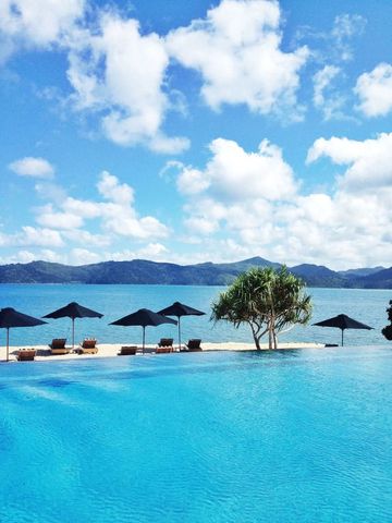 Infinity-Pool mit Blick auf das Meer und Berge im Hintergrund