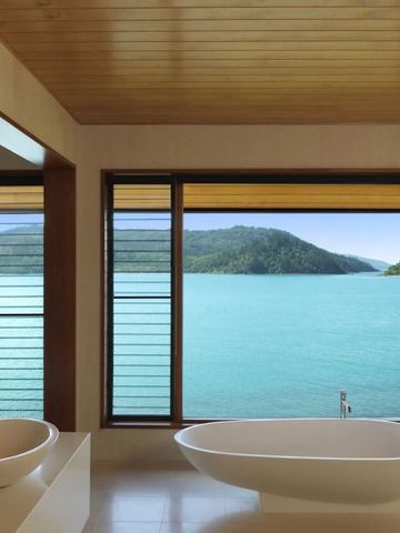 Luxuriöses Badezimmer mit freistehender Badewanne und Meerblick