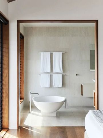 Modernes Badezimmer mit freistehender Badewanne und Handtüchern